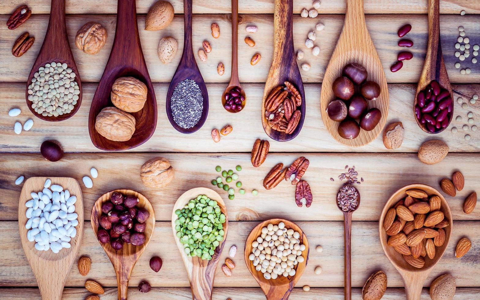 Hülsenfrüchte und Nüsse auf Holzlöffeln foto