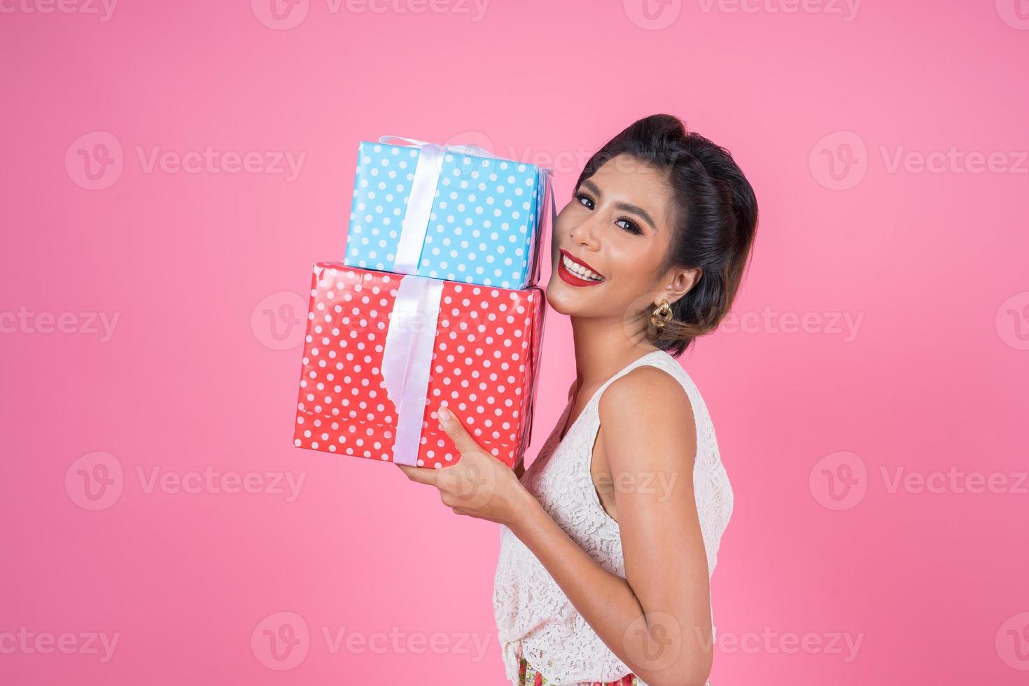 schöne glückliche Frau mit Überraschungsgeschenkboxen foto