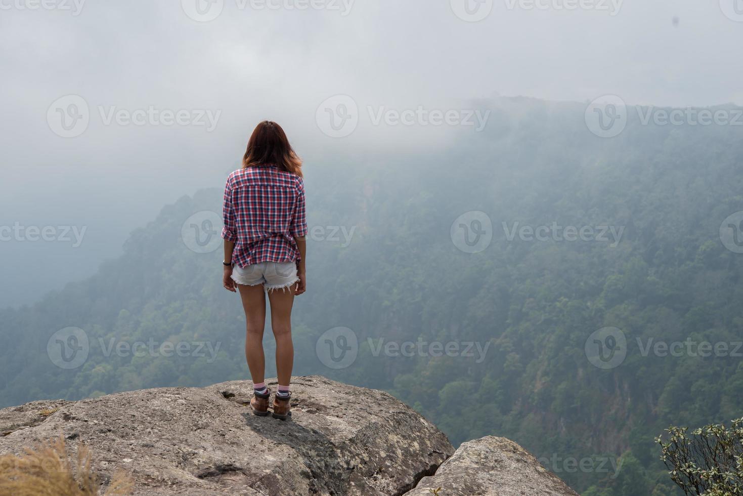 Rückseite des Wanderers, der auf einem Berg steht und Naturblick genießt foto