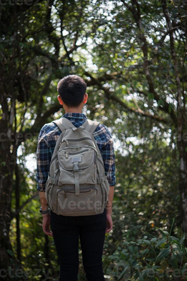 junger Hipster-Mann Wanderer, der sich beim Wandern ausruht foto