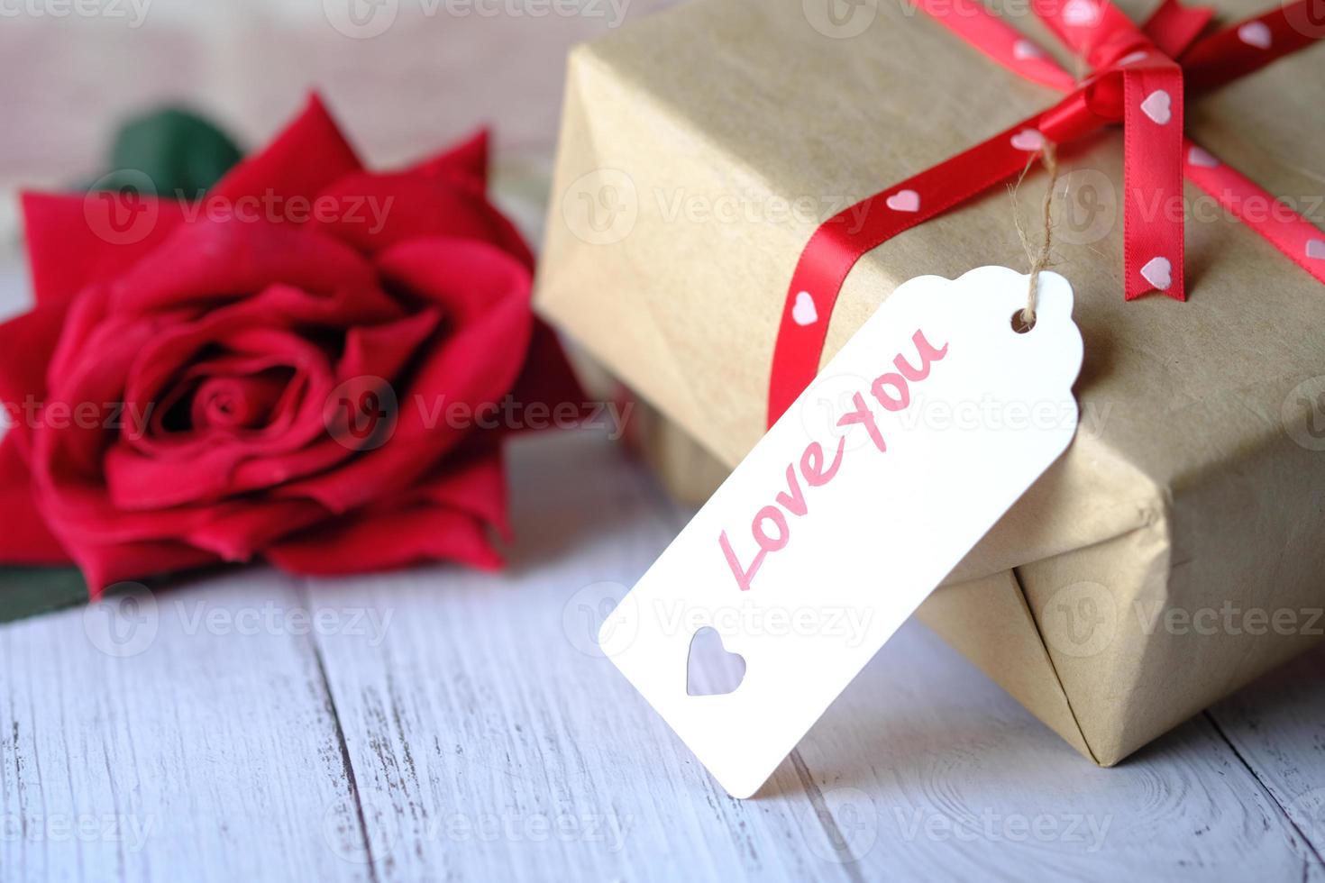 Geschenkbox mit Liebe Sie Tag und Rosenblume auf weißem Hintergrund foto