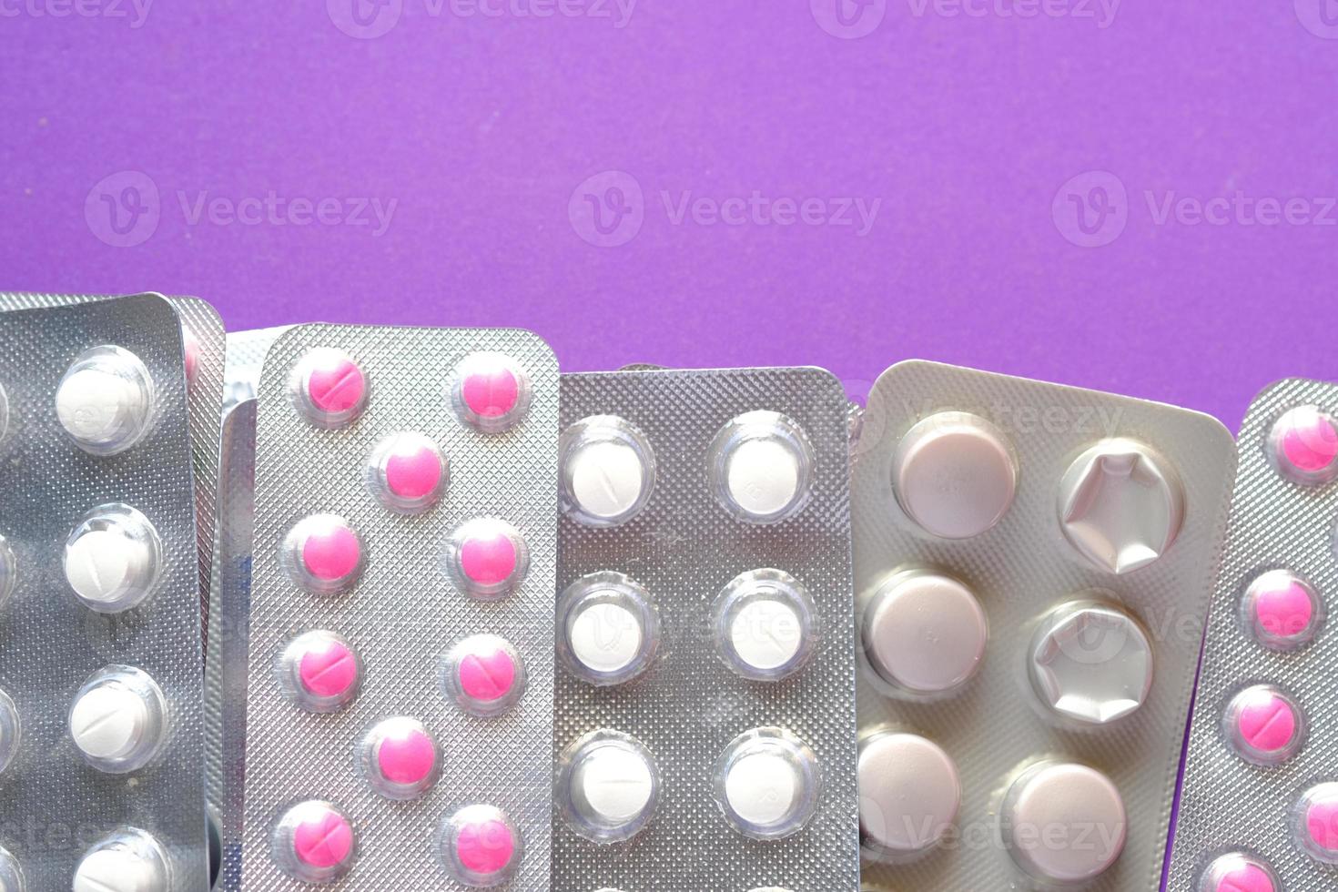 Nahaufnahme von Pillen in Blisterpackungen auf lila Hintergrund foto