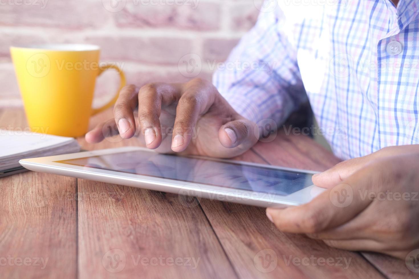 Geschäftsmann, der Finger auf digitalem Tablettbildschirm auf Schreibtisch zeigt foto