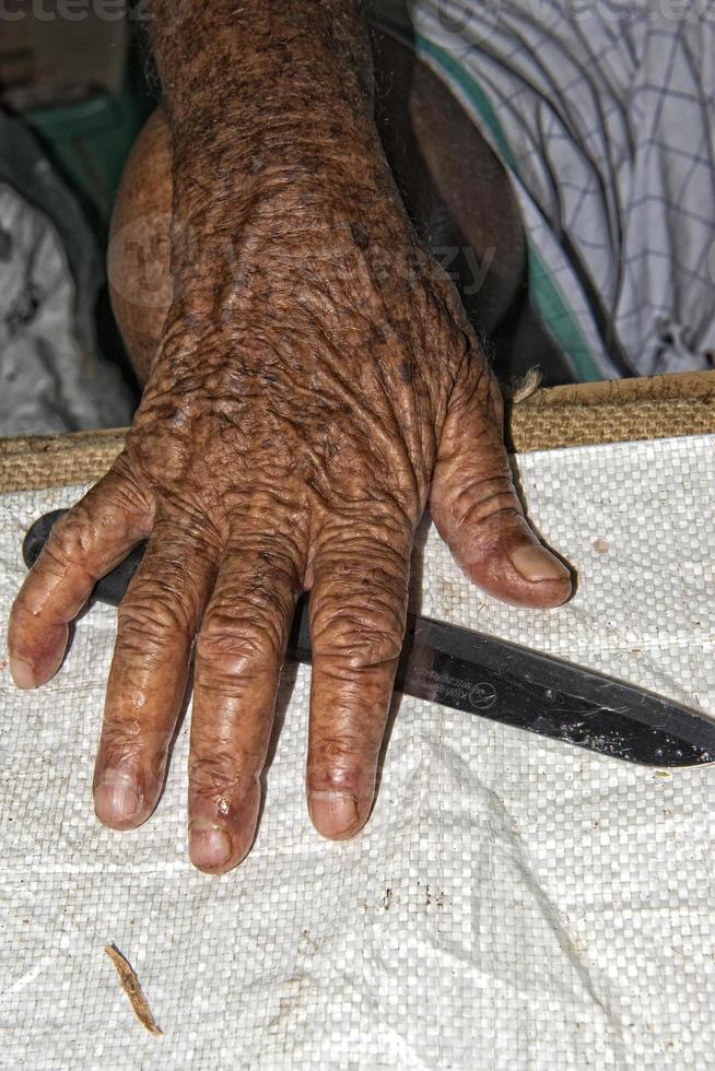 Hand des alten Mannes auf einem Fischerboot foto