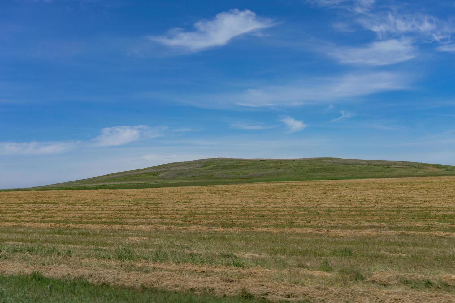 Landschaft mit Feldern und Hügeln und bewölktem blauem Himmel foto