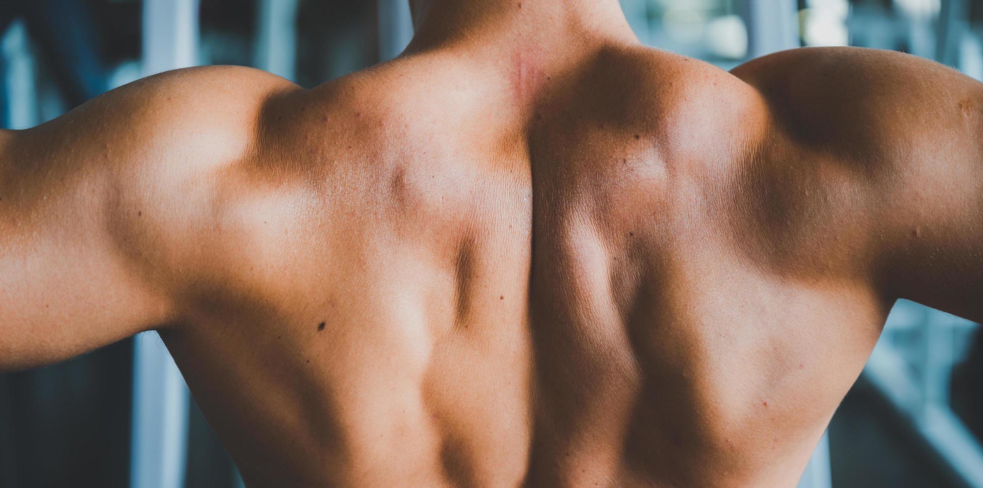 Nahaufnahme der Rückenmuskulatur des Mannes in einem Fitnessstudio foto