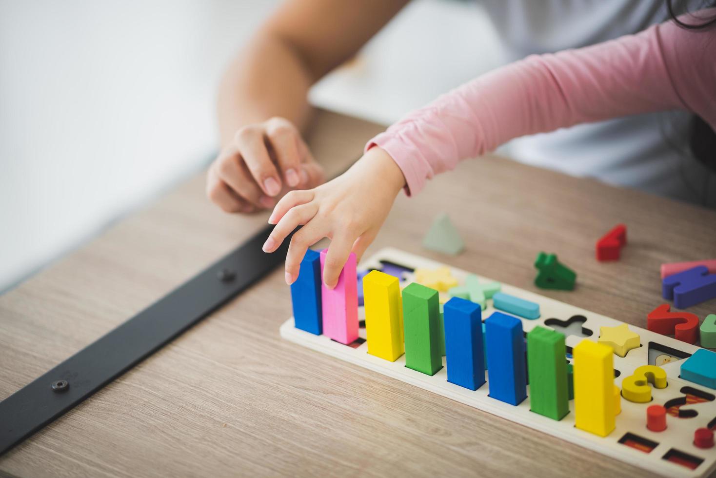 Eltern und Mädchen spielen mit Ziegelblöcken foto