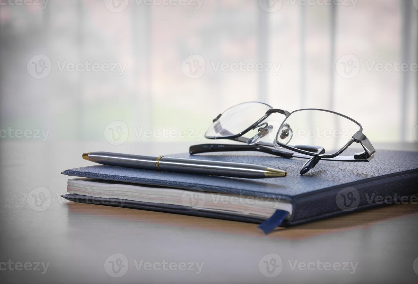 Brille und Stift auf einem Buch foto