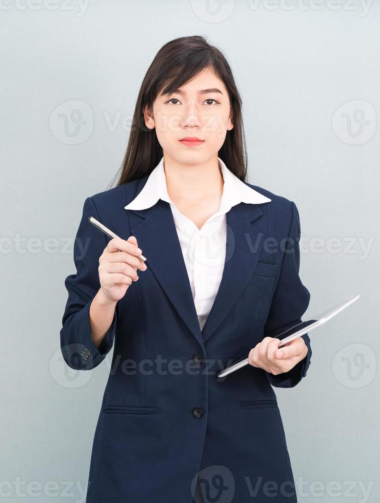 Frau im Anzug mit digitalem Tablet auf grauem Hintergrund foto