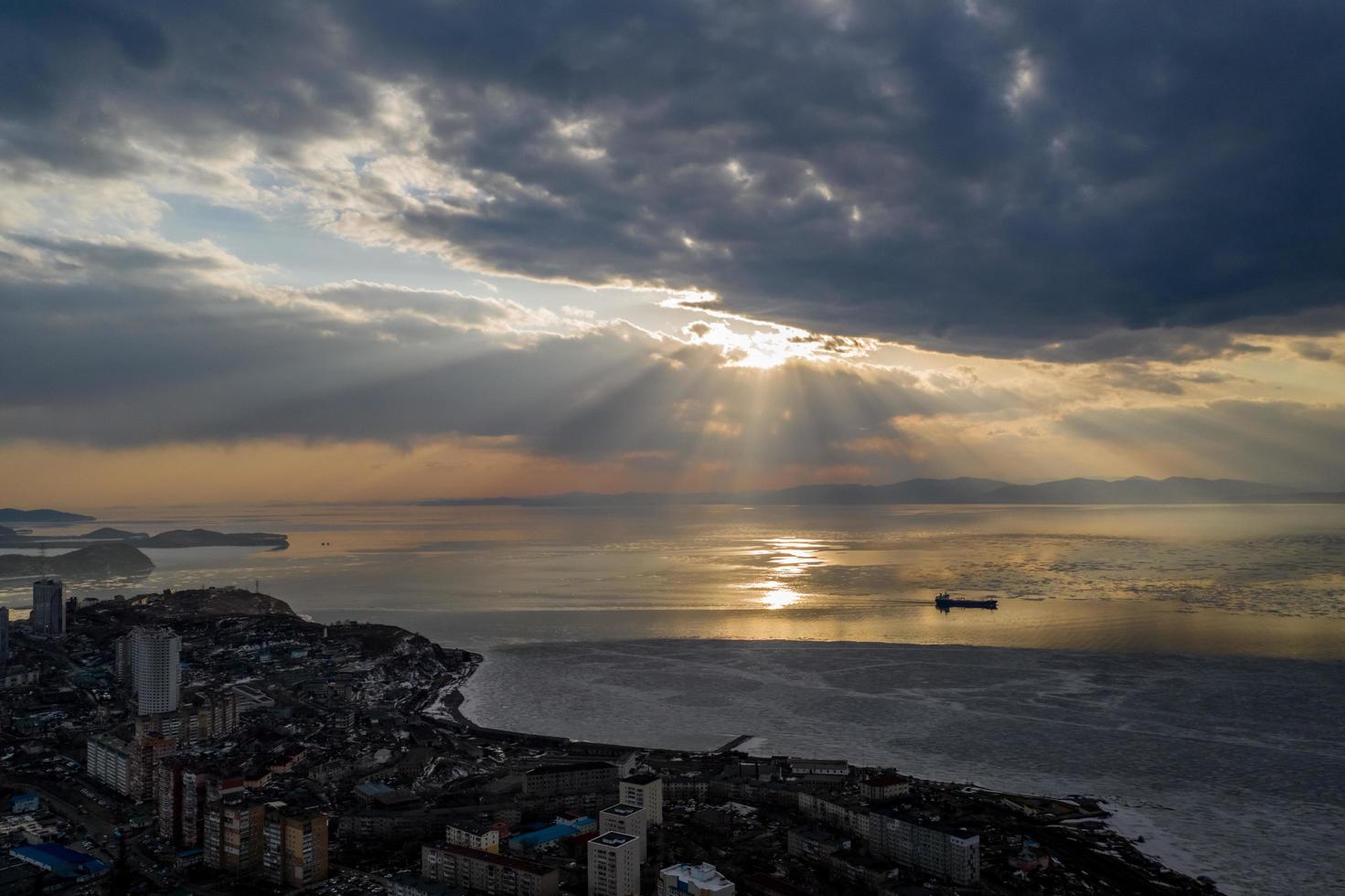 Luftaufnahme der Amur-Bucht mit Sonnenlicht, das durch Wolken in Wladiwostok, Russland bricht foto