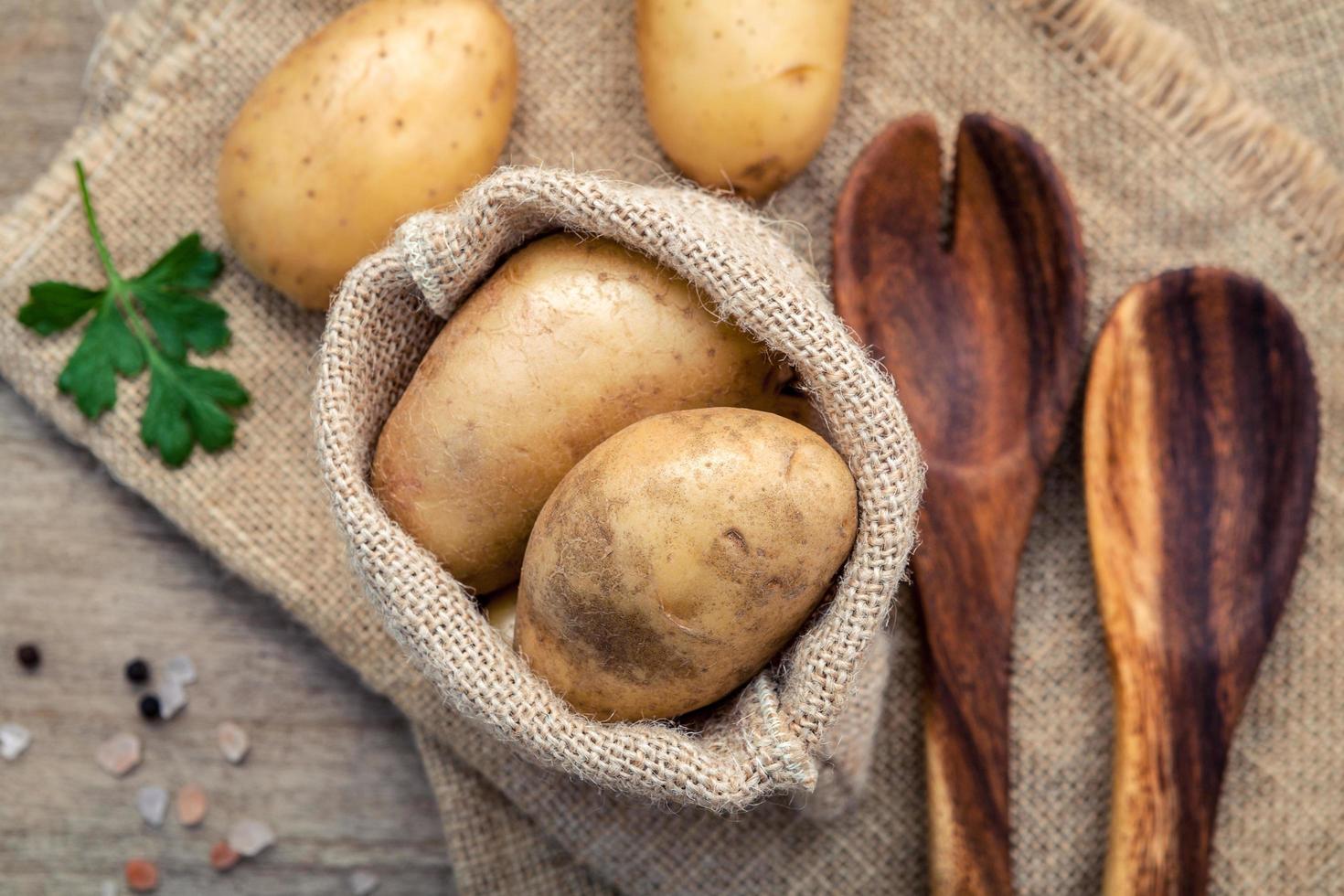 Kartoffeln im Sack mit Holzutensilien foto