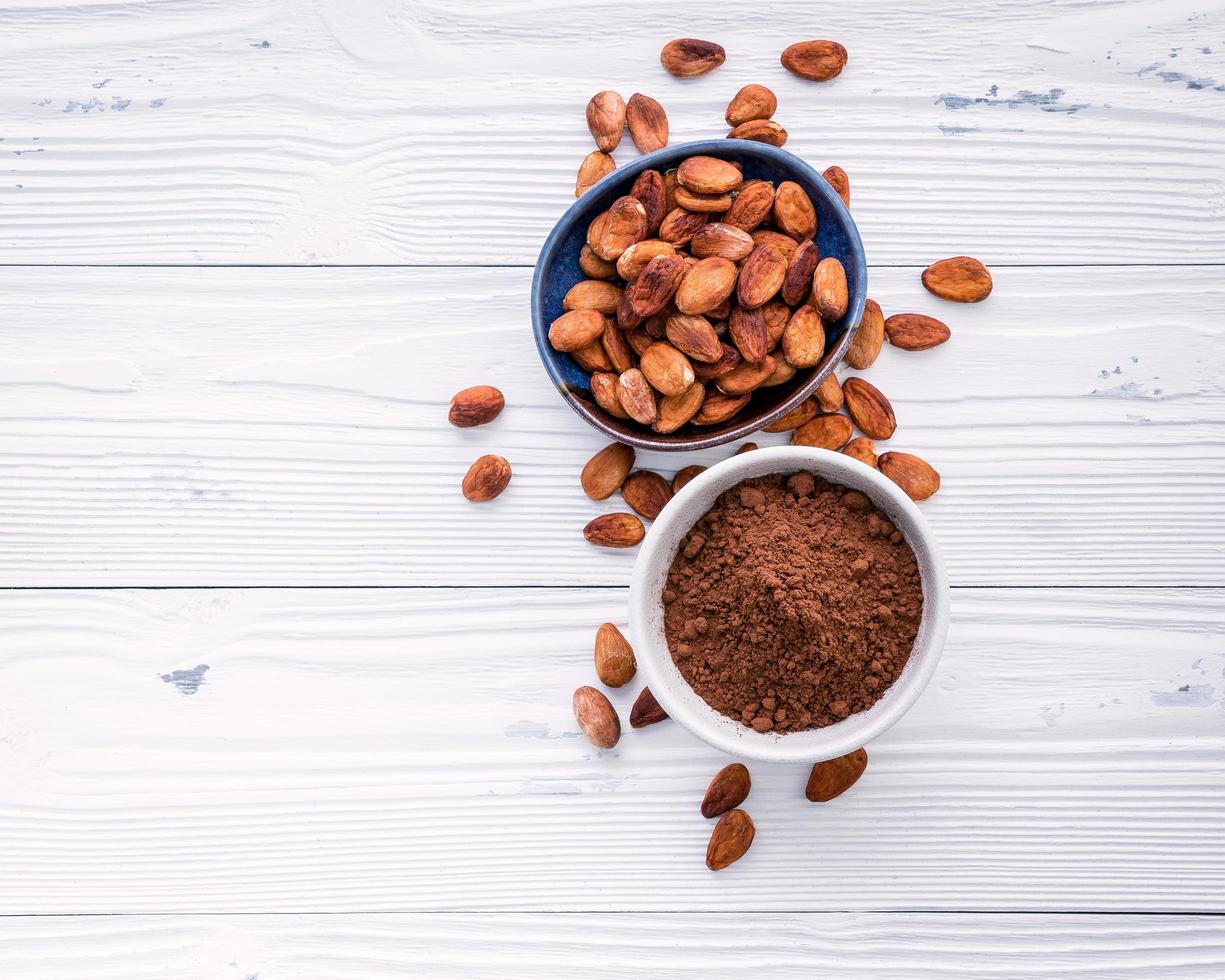 Kakaopulver und Kakaobohnen auf schäbigem weißem Hintergrund foto