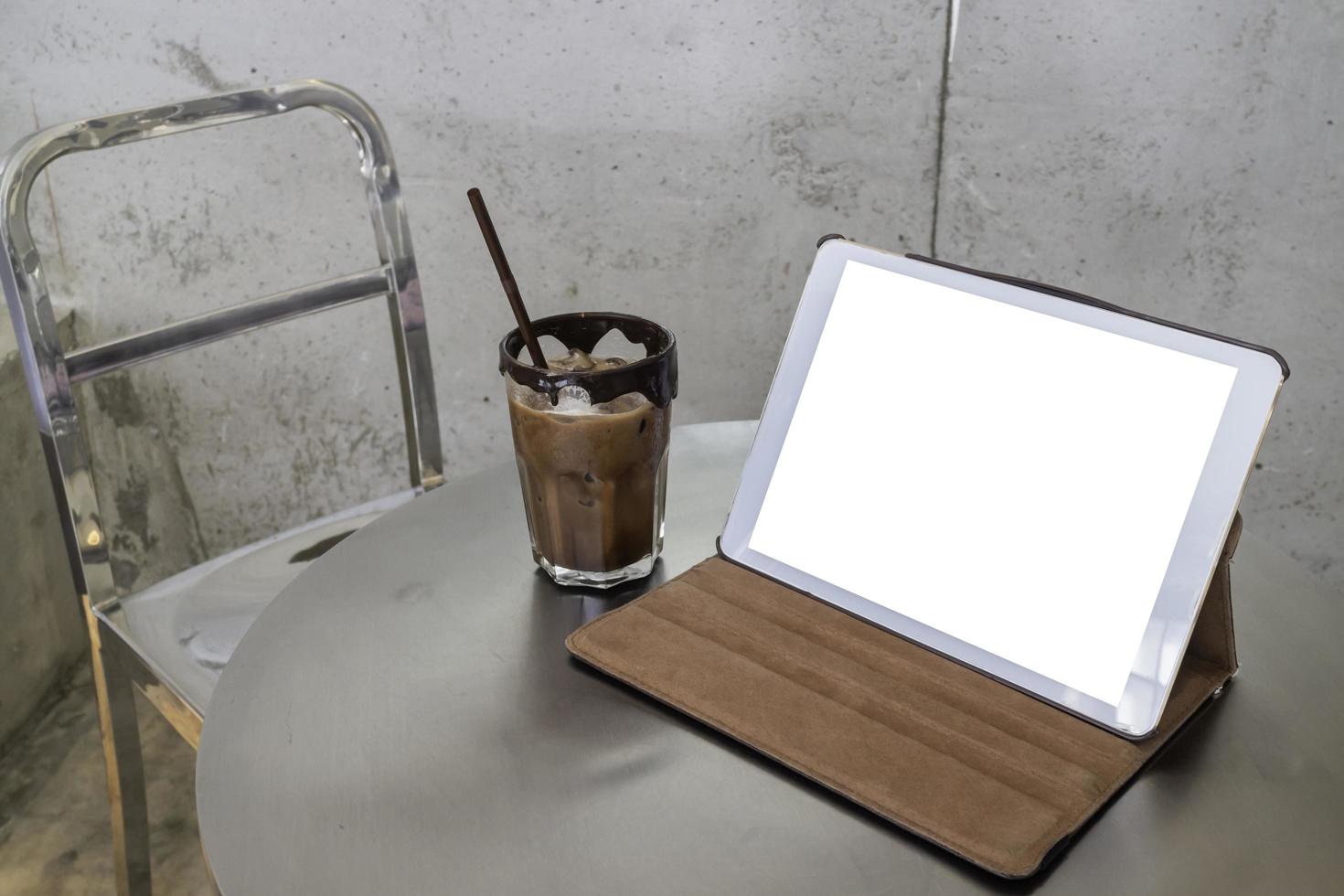 Handy arbeitet in einem Café mit Tablett mit leerem Bildschirm foto