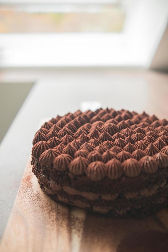 Schokoladenkuchen auf dem Küchentisch mit minimalistischem Hintergrund foto