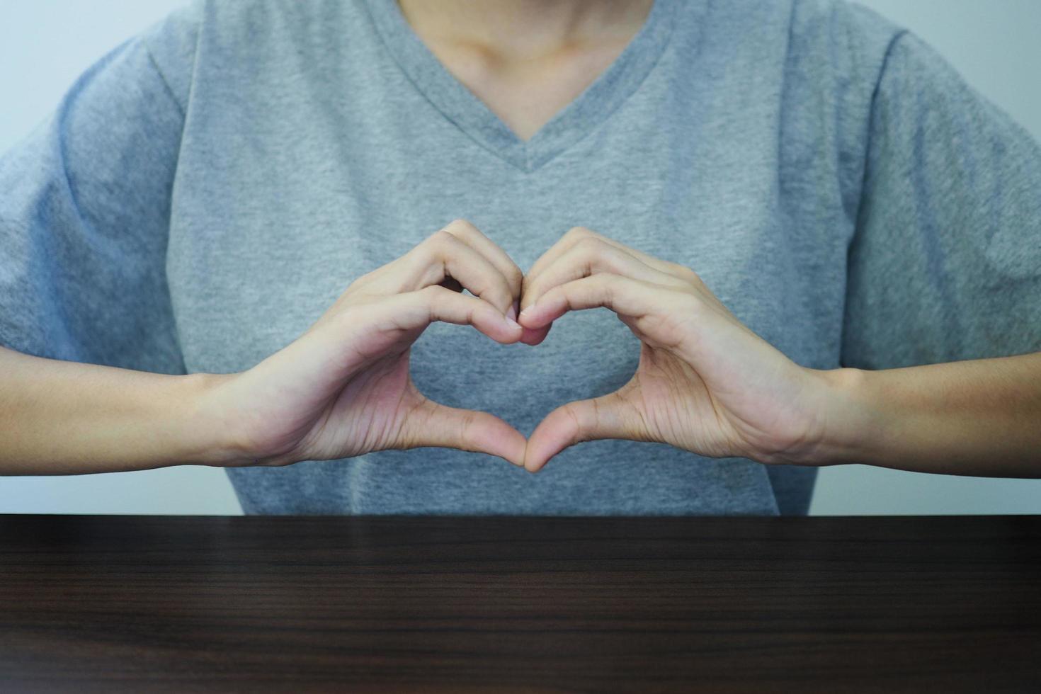 Nahansicht Aussicht von Hand Schuss von schön jung Frau Herstellung Herz Geste. Konzept von Liebe und Glück. foto