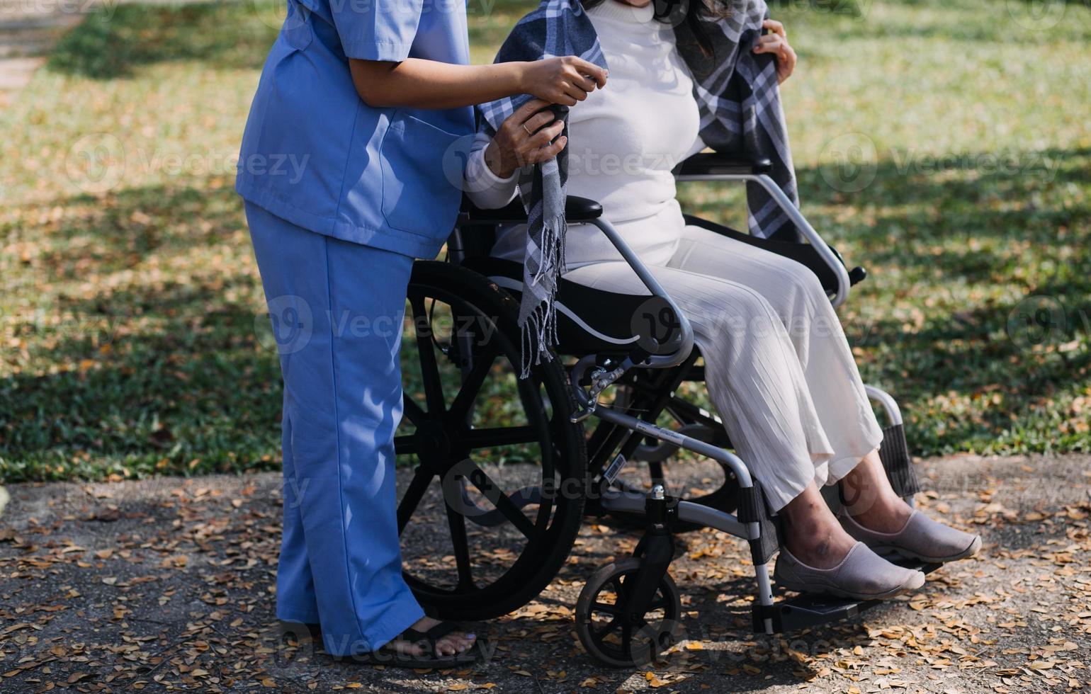 asiatisch jung Pflegekraft Krankenschwester Unterstützung Senior älter männlich Gehen draußen. Spezialist Mädchen Arzt Hilfe und nehmen Pflege von Alten reifen Mann geduldig tun physisch Therapie im Öffentlichkeit Park beim Pflege- heim. foto