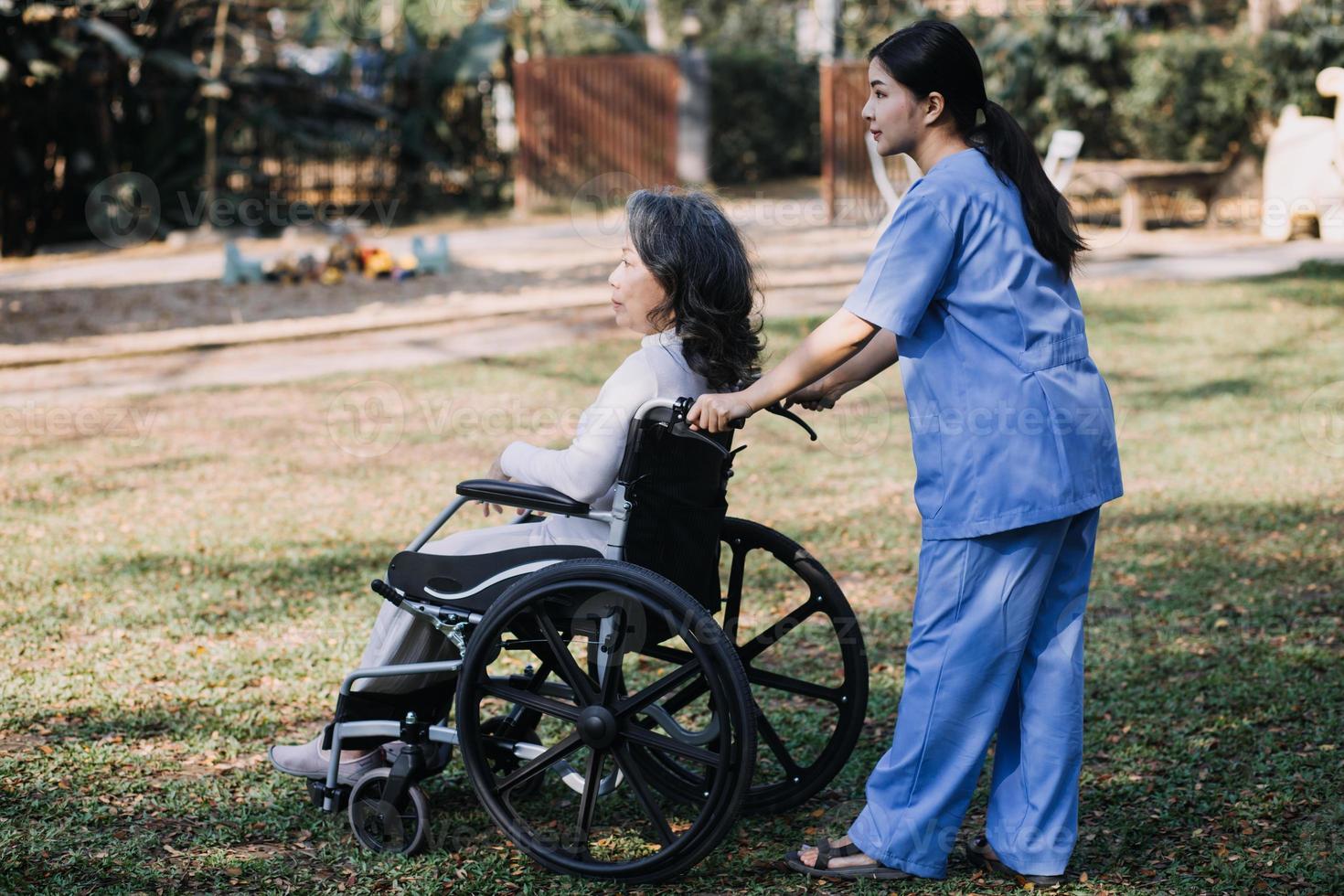 asiatisch jung Pflegekraft Krankenschwester Unterstützung Senior älter männlich Gehen draußen. Spezialist Mädchen Arzt Hilfe und nehmen Pflege von Alten reifen Mann geduldig tun physisch Therapie im Öffentlichkeit Park beim Pflege- heim. foto