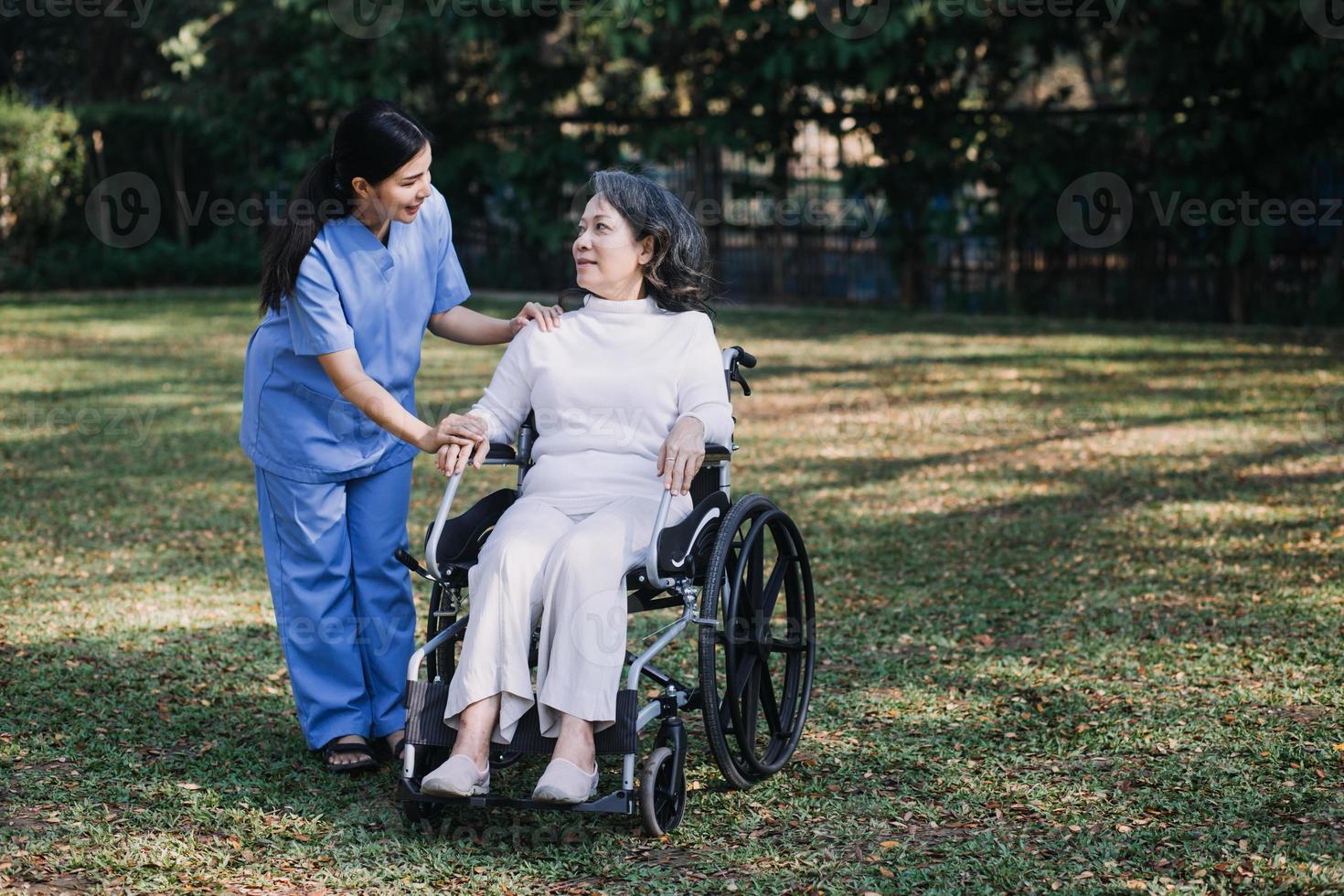 asiatisch jung Pflegekraft Krankenschwester Unterstützung Senior älter männlich Gehen draußen. Spezialist Mädchen Arzt Hilfe und nehmen Pflege von Alten reifen Mann geduldig tun physisch Therapie im Öffentlichkeit Park beim Pflege- heim. foto