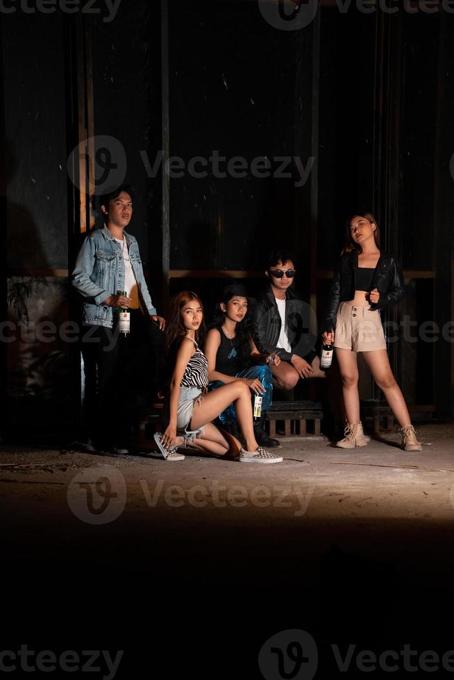 ein Gruppe von Jugendliche im schrullig Kleider posieren zusammen wie freunde im ein Disko Bar mit ein sehr cool Ausdruck foto