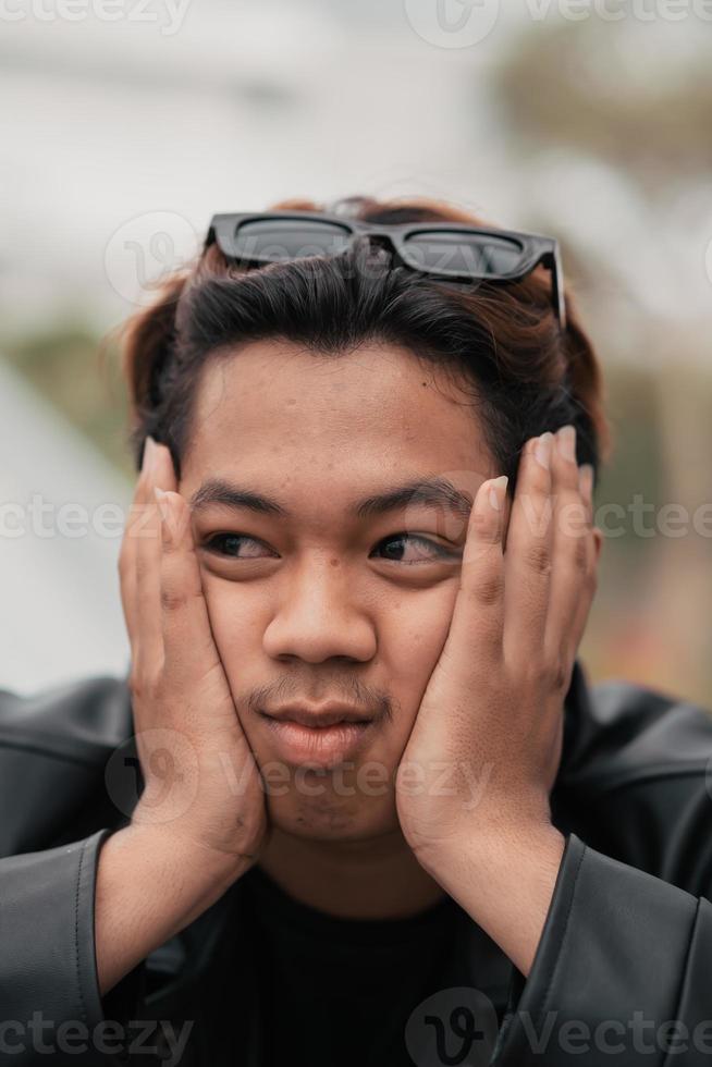 das Gesicht von ein sehr dumm asiatisch Mann mit Sonnenbrille auf seine Kopf während entspannend im ein Cafe foto