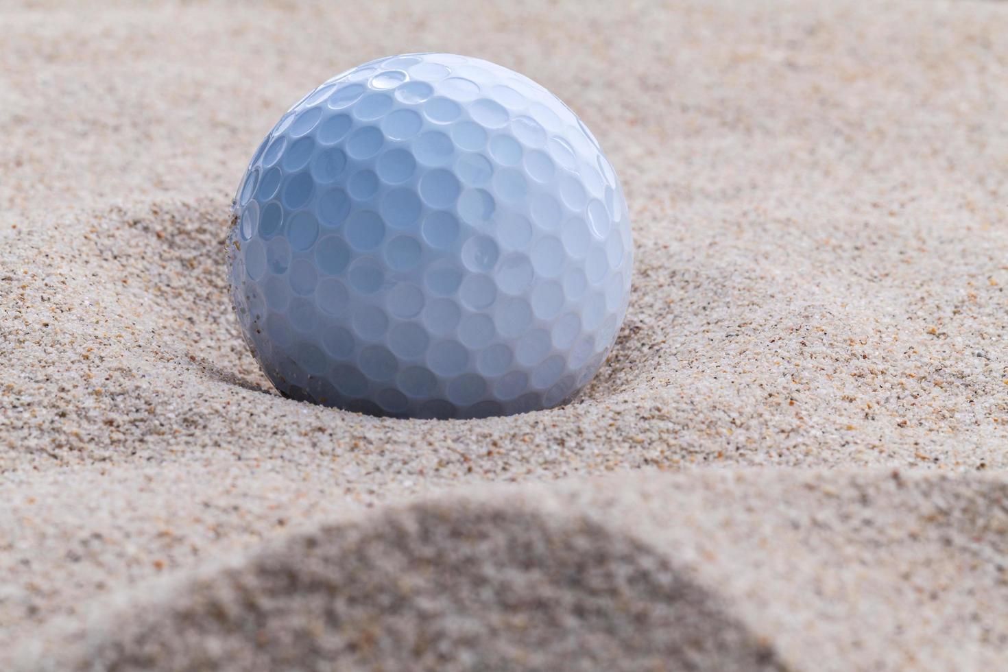 Nahaufnahme eines Golfballs im Sand während des Tages foto