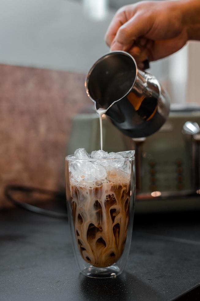 Glas Kaffee mit Milch auf dem Tisch foto