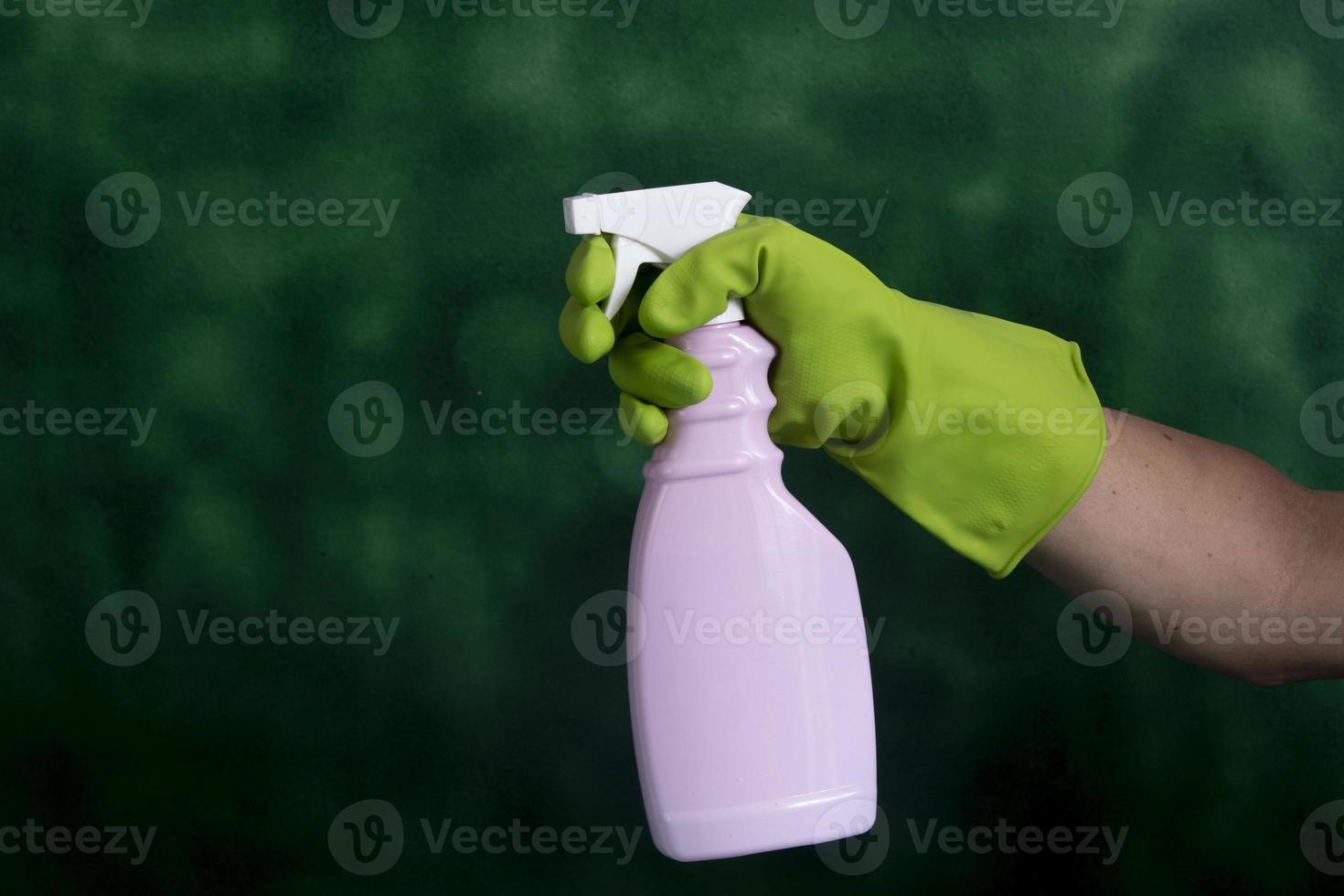 hand mit schutzhandschuh, der verpackungen von reinigungsprodukten hält, die für die haushaltshygiene verwendet werden foto