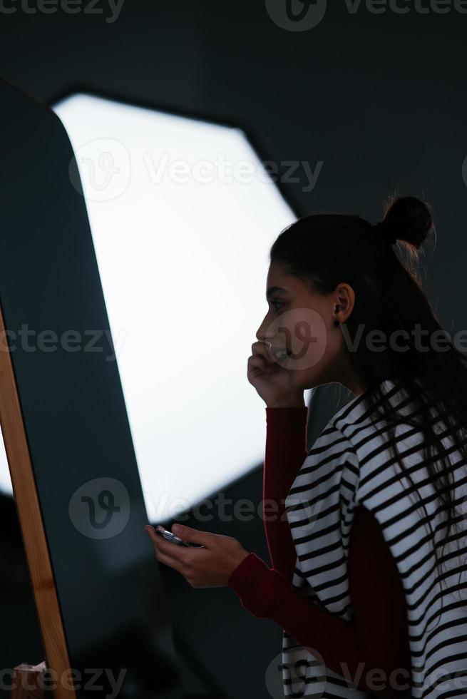 junge Frau schminkt ihr Gesicht vor dem Spiegel foto