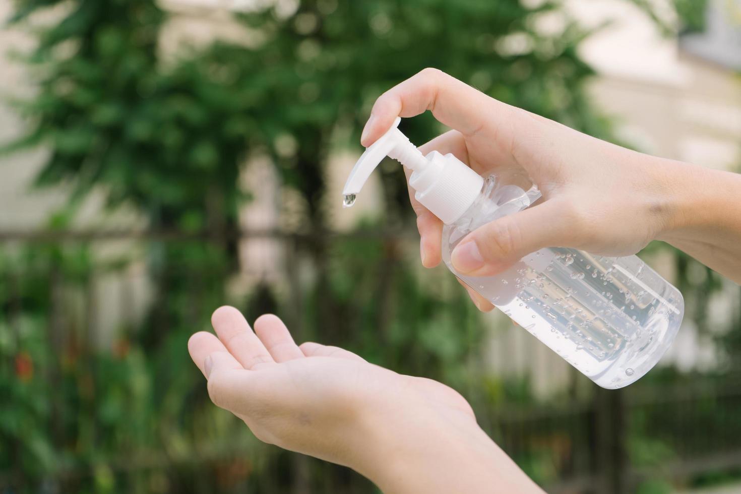 Frau, die Hand mit Alkoholgel putzt foto