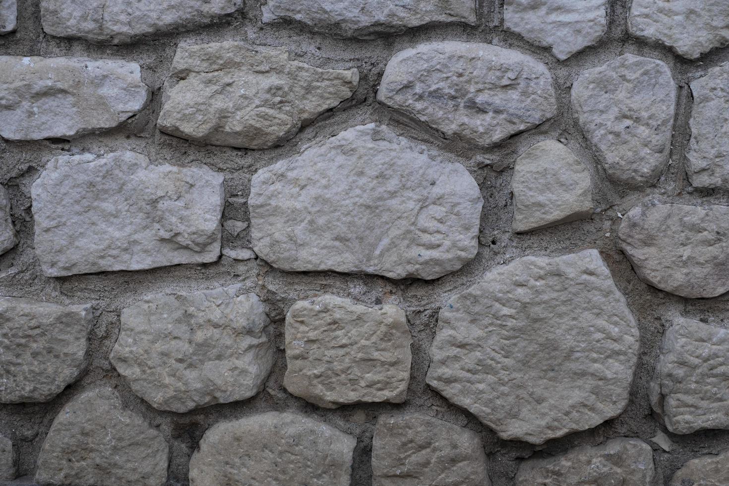 Steinmauerbeschaffenheit, dekorativer Wandhintergrund mit Mosaiksteinen foto