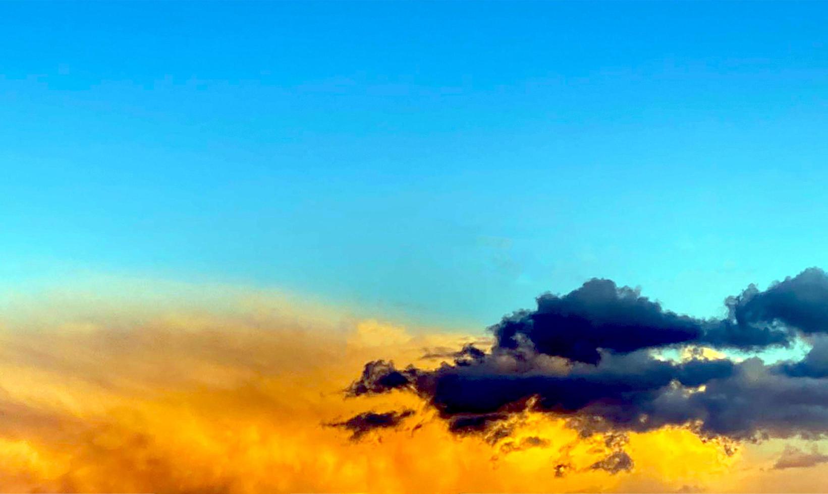 Ängstlich Sonnenuntergang. grau und Orange Wolken im Blau Himmel. foto