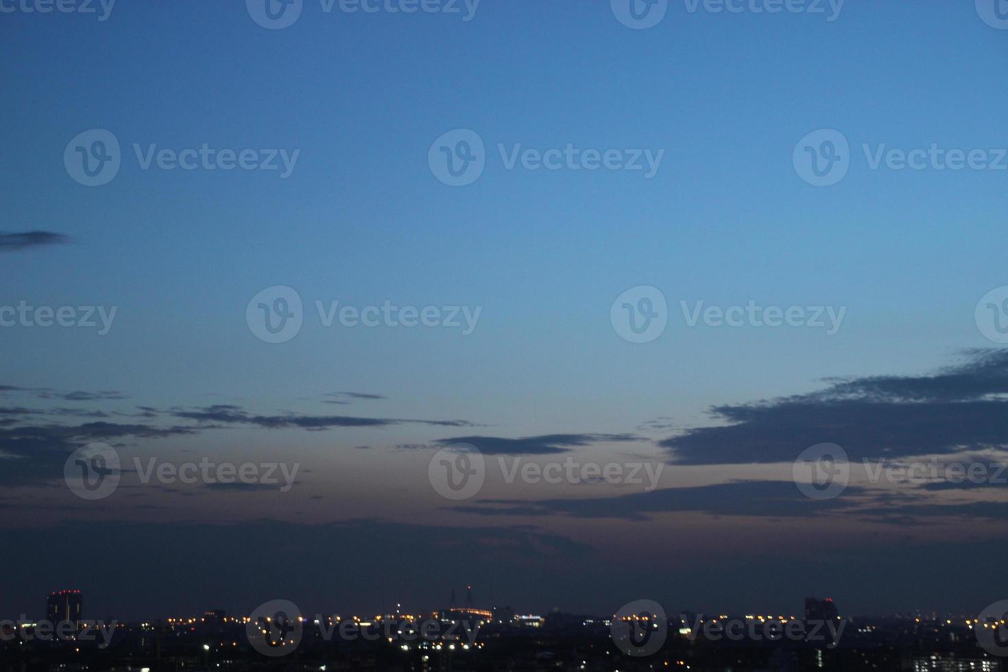 dunkel Blau Wolke mit Weiß Licht Sonnenuntergang Himmel Hintergrund und Stadt Licht Mitternacht Abend Zeit foto