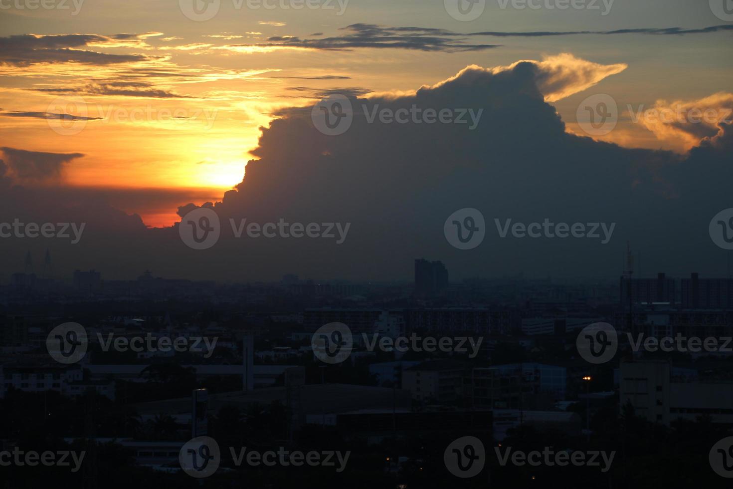 dunkel Blau Wolke mit Weiß Licht Sonne einstellen Himmel Hintergrund und Stadt Licht Mitternacht Abend Zeit foto