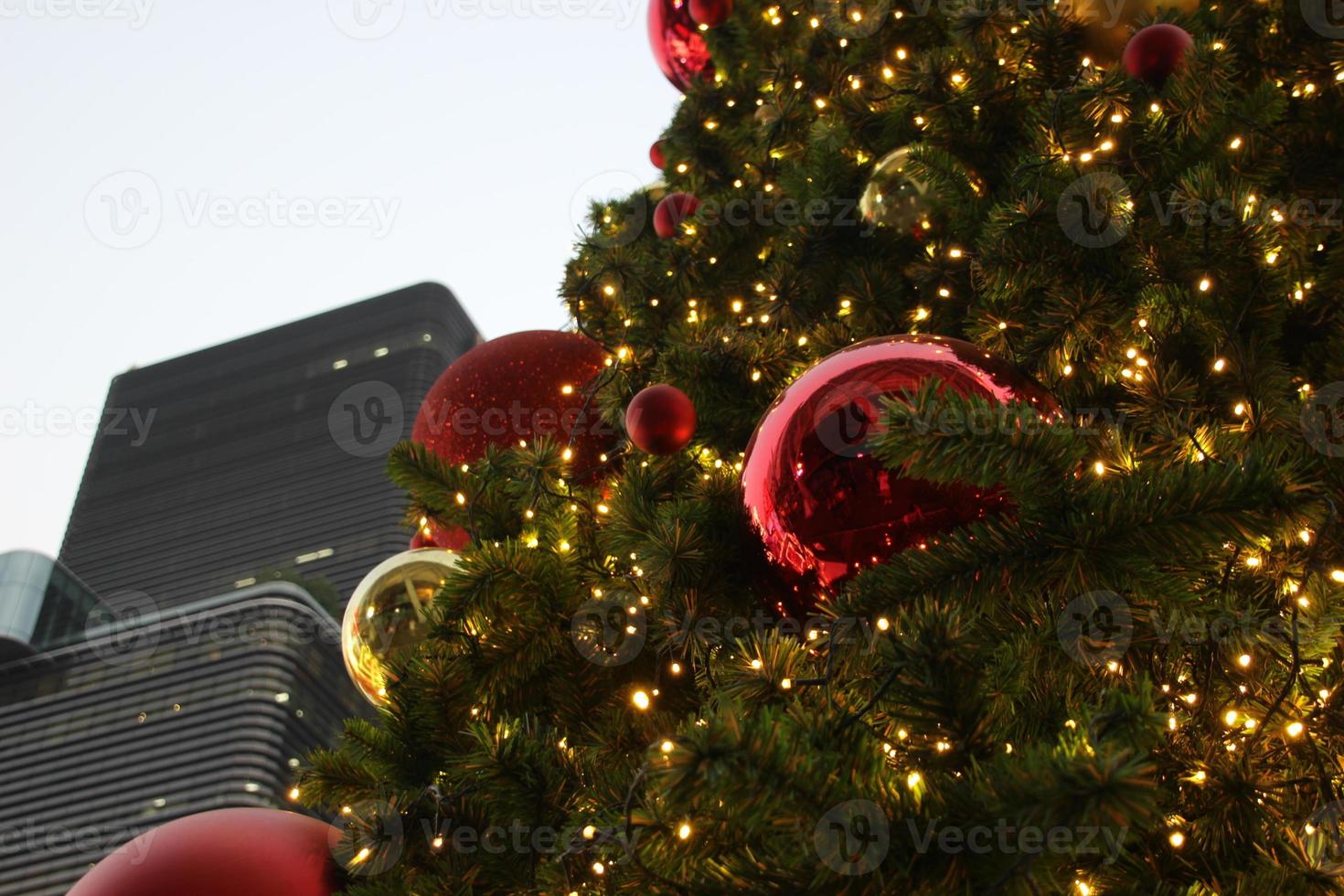 Grün Kiefer Weihnachten Baum mit Licht funkeln und rot Gold Dekoration und Himmel Hintergrund foto