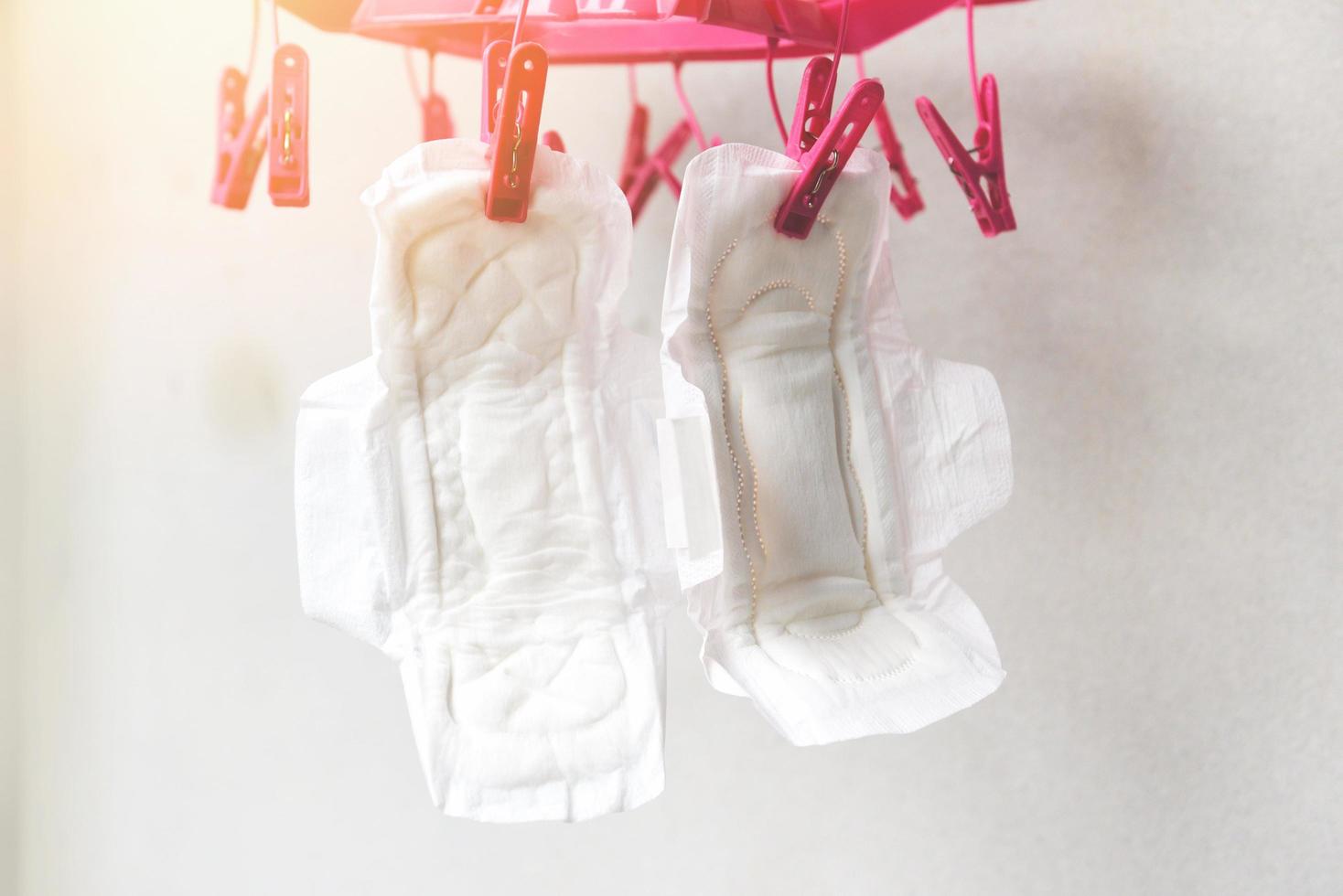 trocken sanitär Serviette oder feminin sanitär Pad im das Sonne Reinigung und getrocknet hängen auf Wäscheklammer Konzept - - weiblich Hygiene meint Frauen Zeitraum Produkt saugfähig Blätter foto