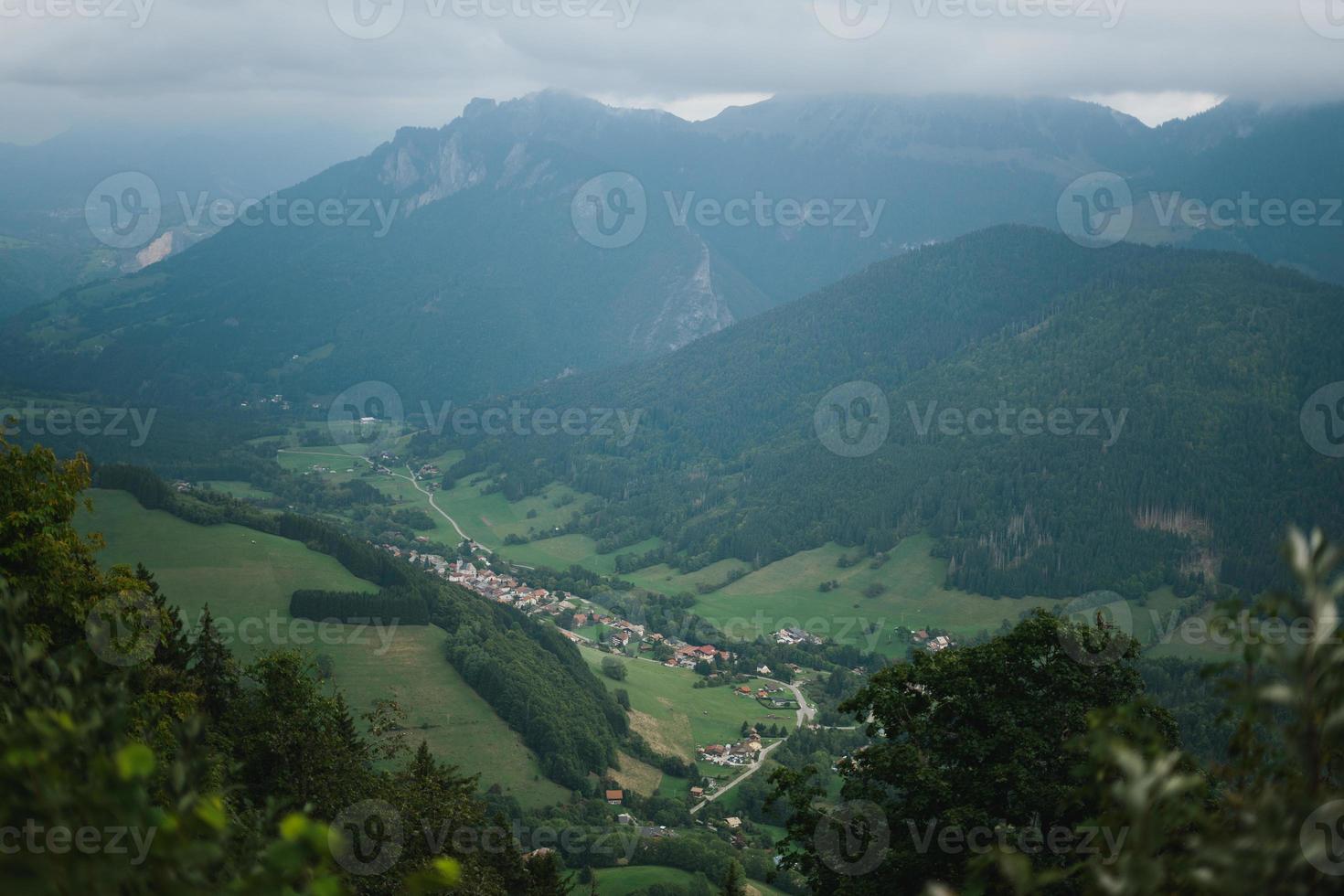 majestätisch Berge im das Alpen bedeckt mit Bäume und Wolken foto