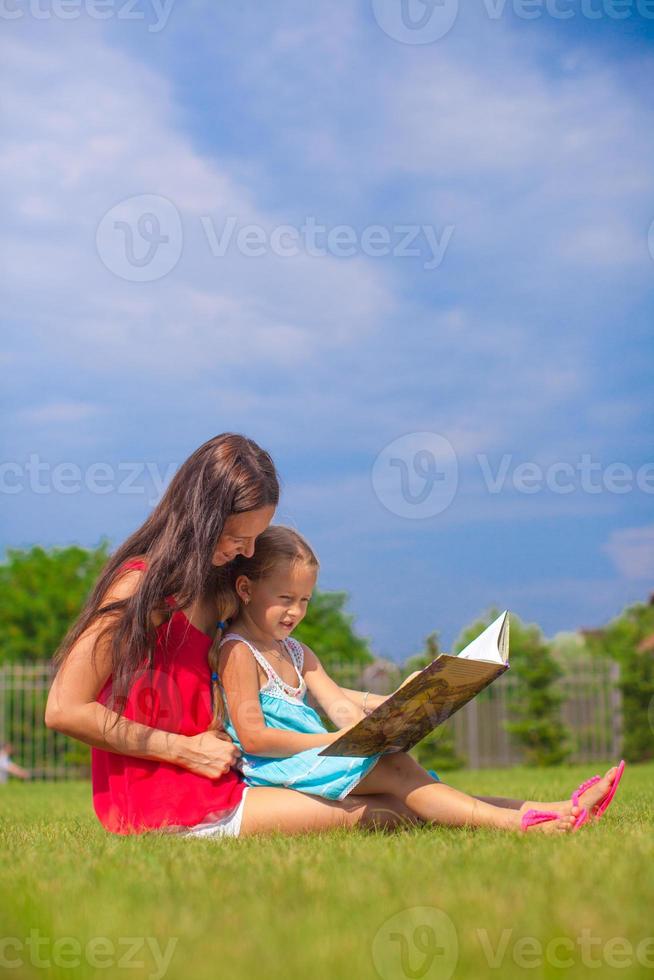 Mutter und Tochter lesen draußen foto