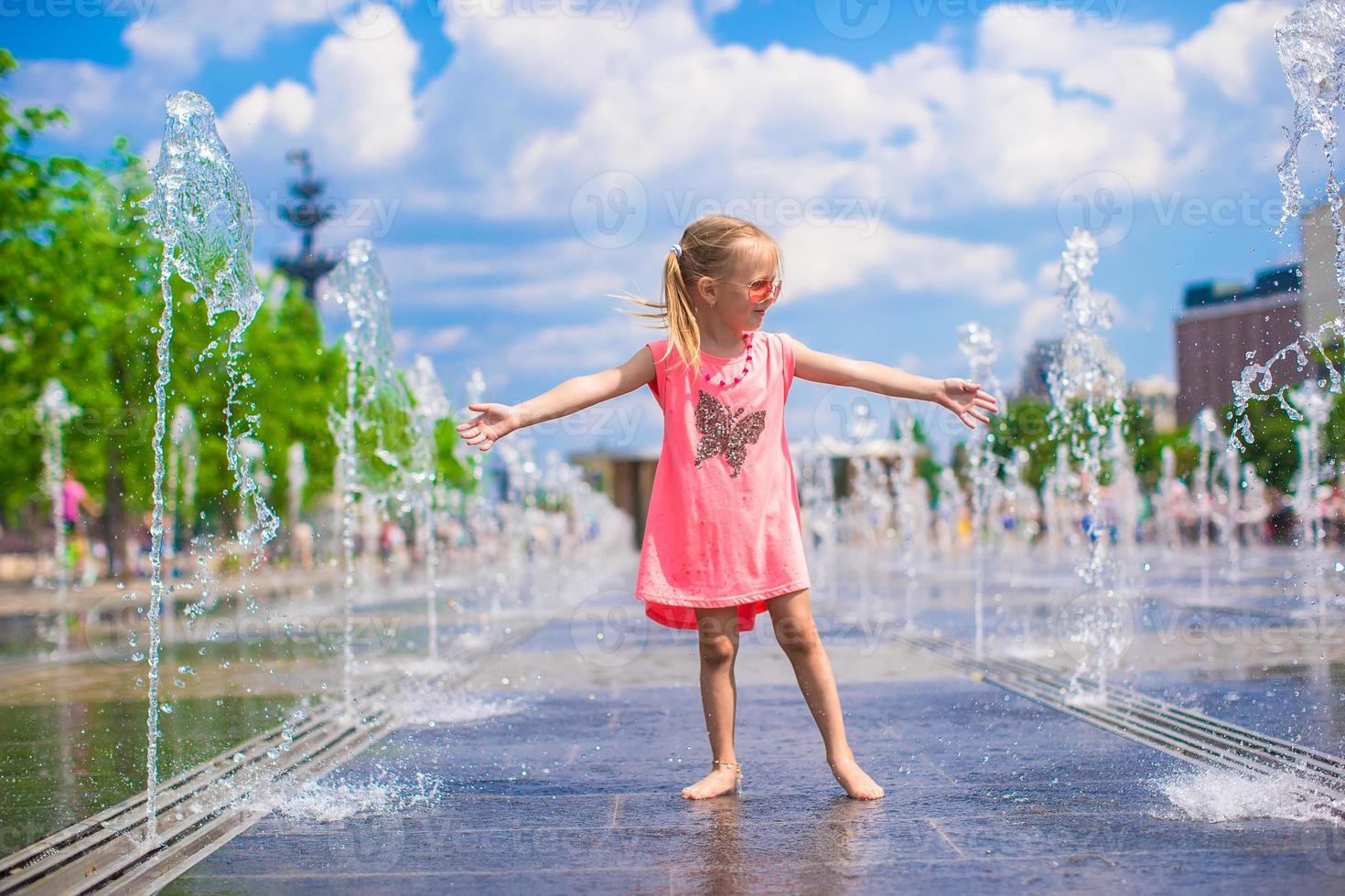 wenig Mädchen spielen auf ein Wasser Brunnen foto
