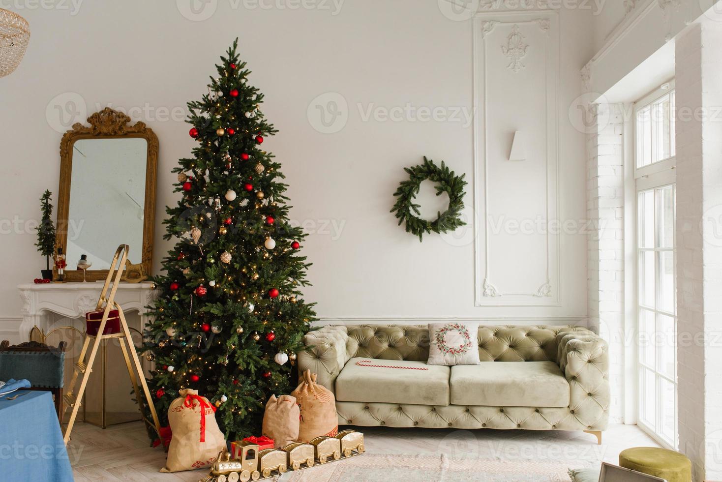 luxuriös Innere von das Leben Zimmer im ein klassisch Stil. Sofa, Weihnachten Baum mit Geschenke durch das Kamin foto