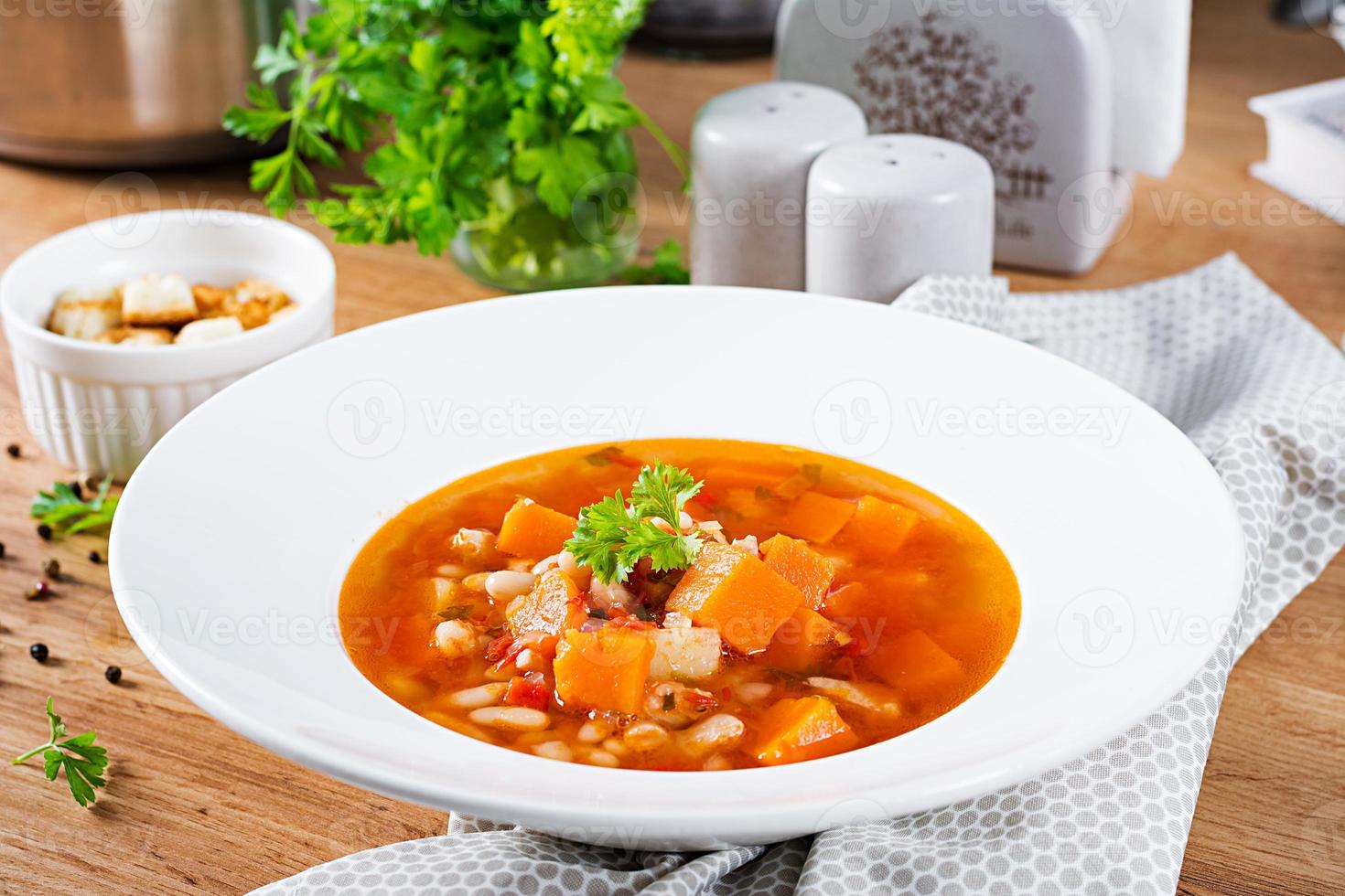 Tomate Hähnchen Suppe mit Kürbis und Weiß Bohnen im Weiß Schüssel. foto