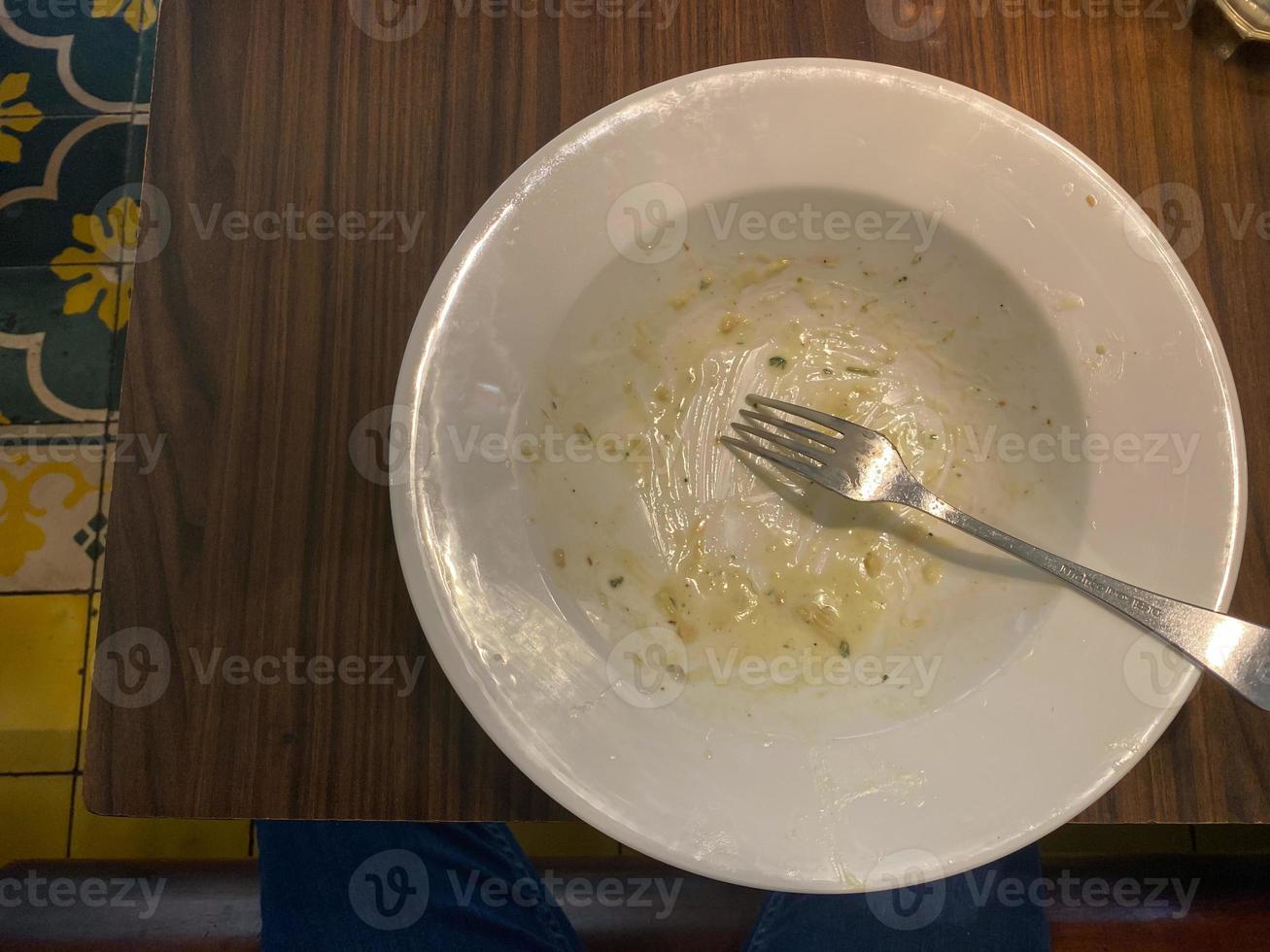 schmutzig Teller mit Essen Reste auf hölzern Hintergrund, oben Aussicht foto