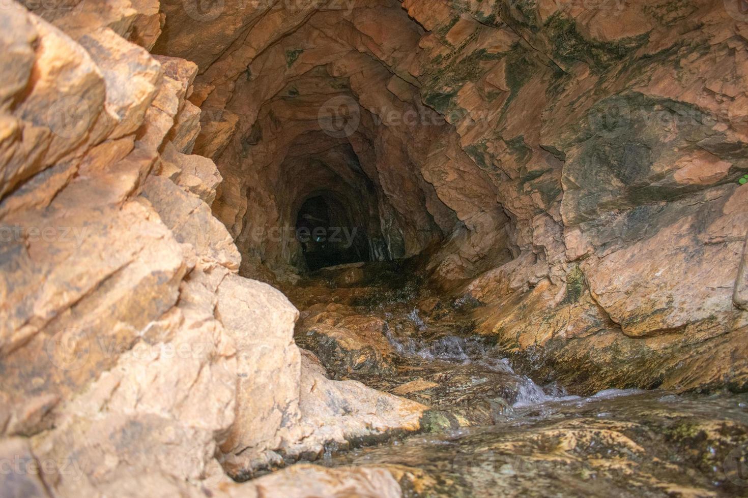 Höhle im felsig Berg mit Fluss auf das Fußboden foto