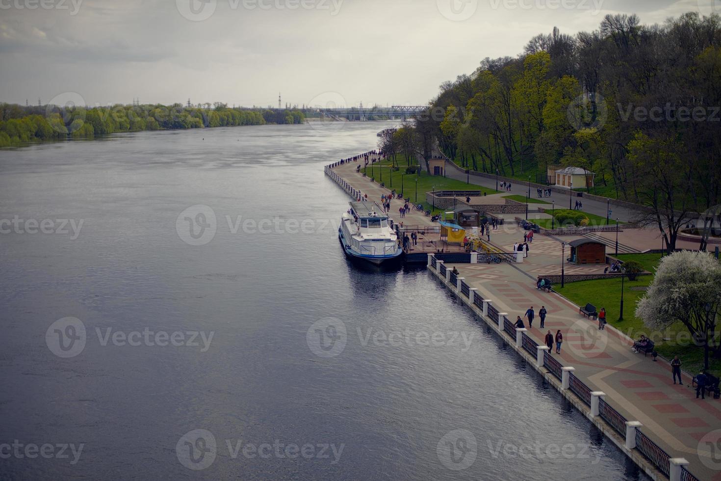 Stadt Damm von das Fluss mit ein Schiff und Fußgänger. Park Bereich von das Stadt. foto