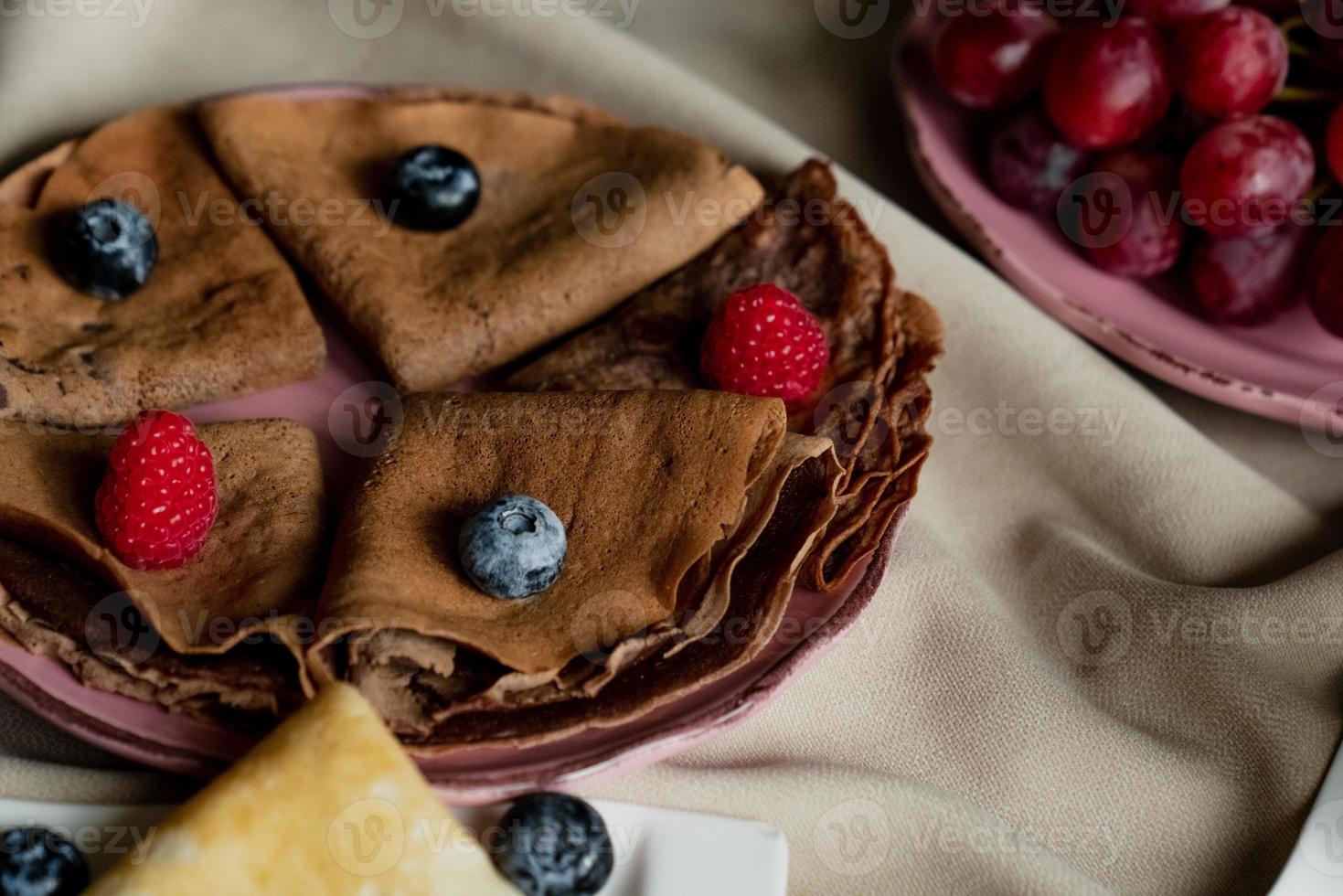 klassisch und Schokolade Pfannkuchen mit Beeren und Früchte zum Frühstück, Schokolade, Tee, foto