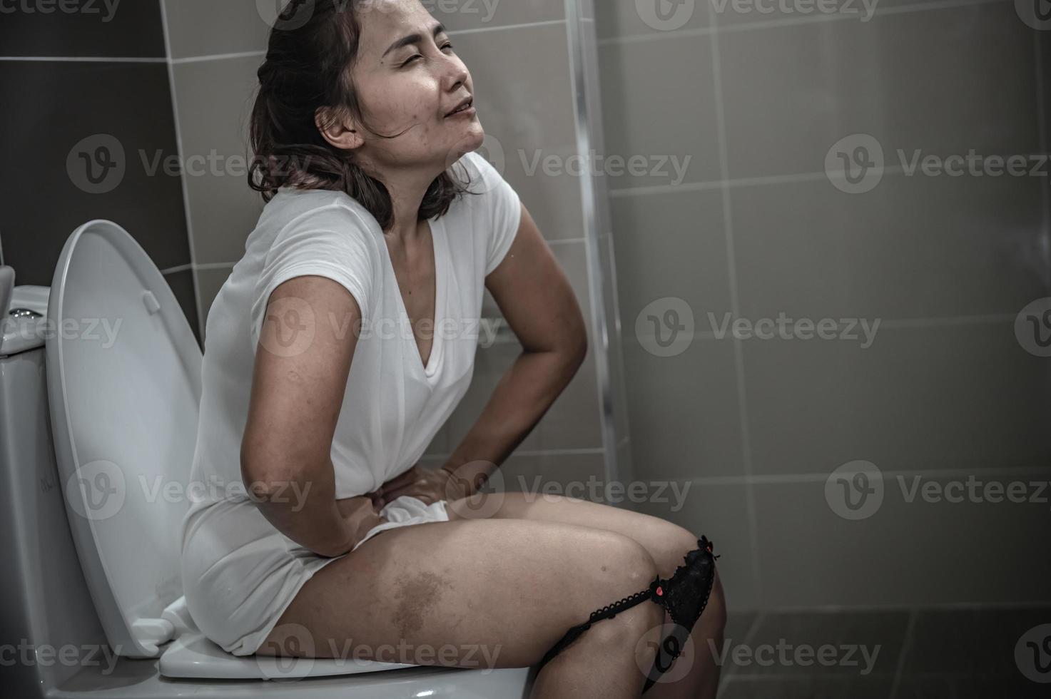 haben Probleme mit Ausscheidung Konzept, ein asiatisch Frau sitzt auf das Toilette Schüssel, Verstopfung und ein lange Zeit im das Toilette. foto