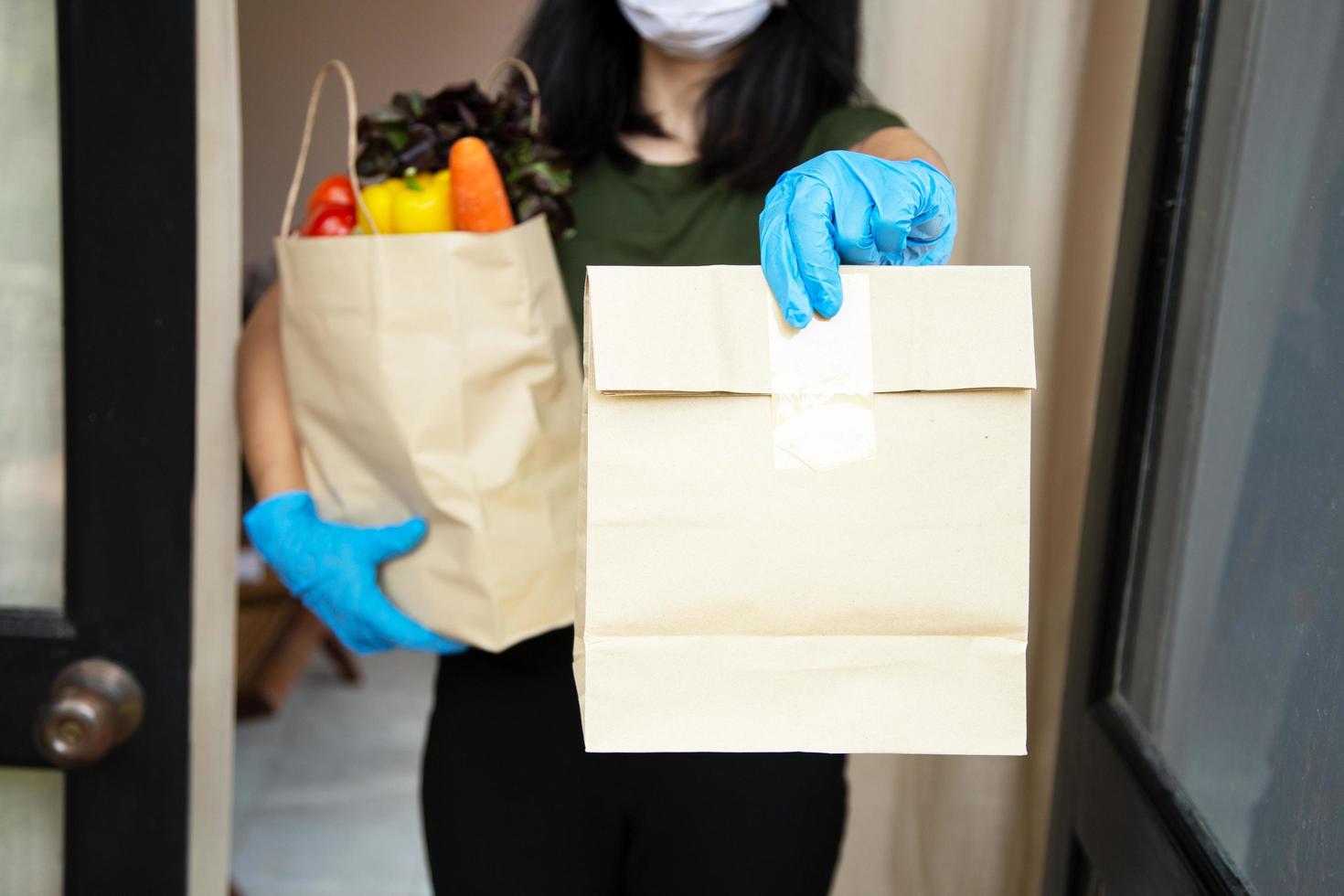 Foodservice-Anbieter mit Masken und Handschuhen. Zu Hause bleiben reduziert die Ausbreitung des Covid-19-Virus foto