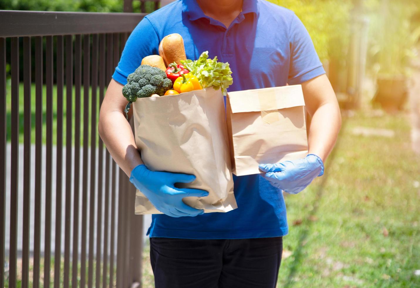 Foodservice-Anbieter mit Masken und Handschuhen. Zu Hause bleiben reduziert die Ausbreitung des Covid-19-Virus foto