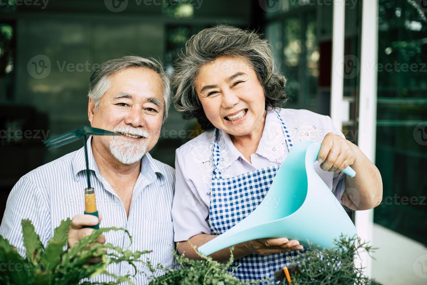 älteres Ehepaar, das zusammen spricht und Bäume in Töpfe pflanzt foto