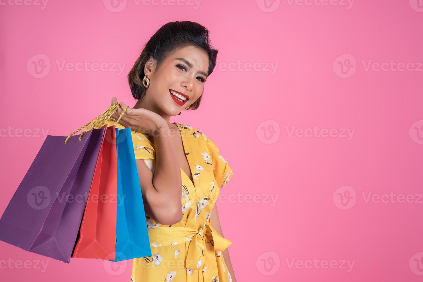 schöne asiatische Frau, die farbige Einkaufstaschen hält foto