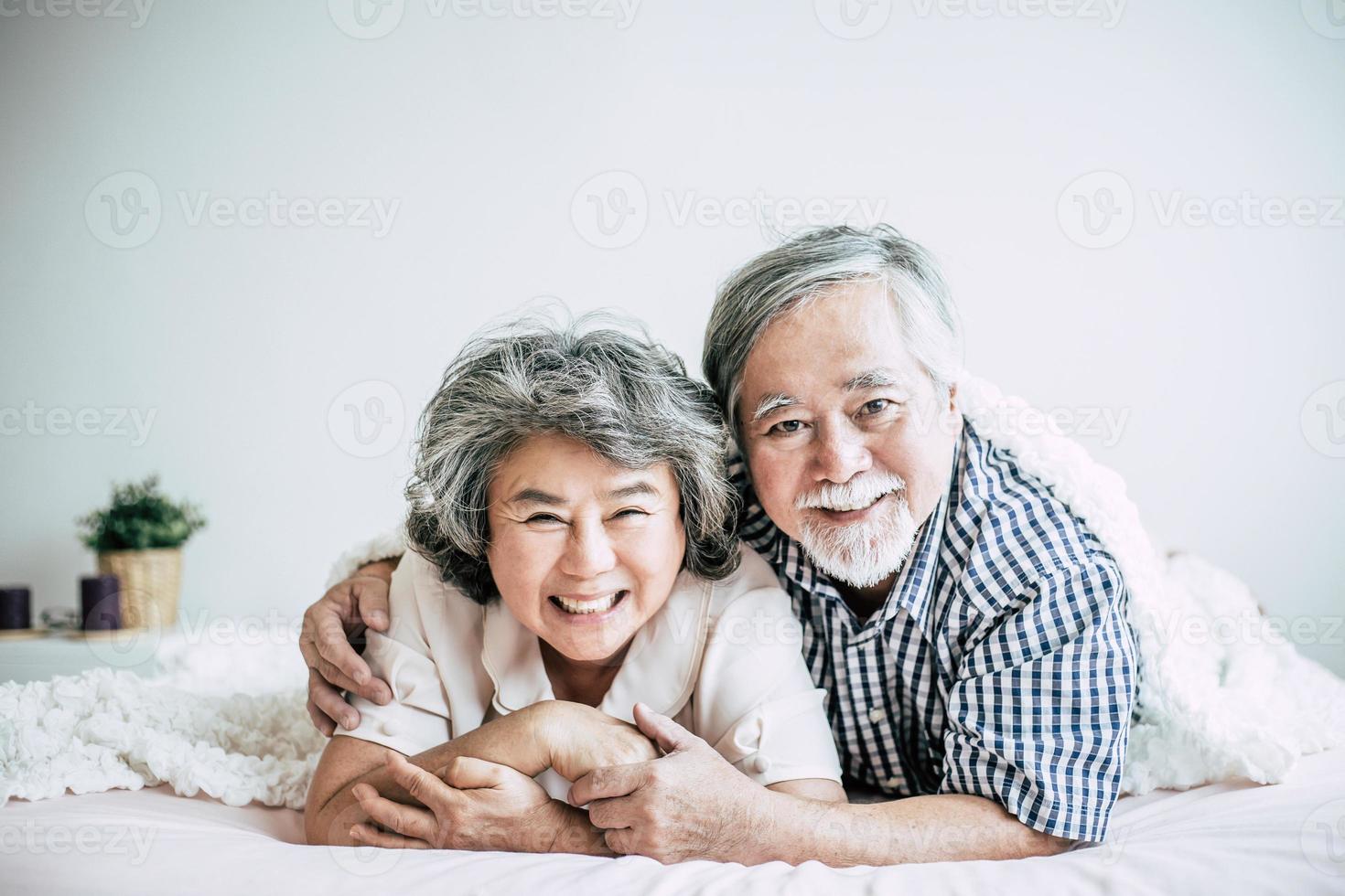 glückliches älteres Paar, das im Schlafzimmer lacht foto